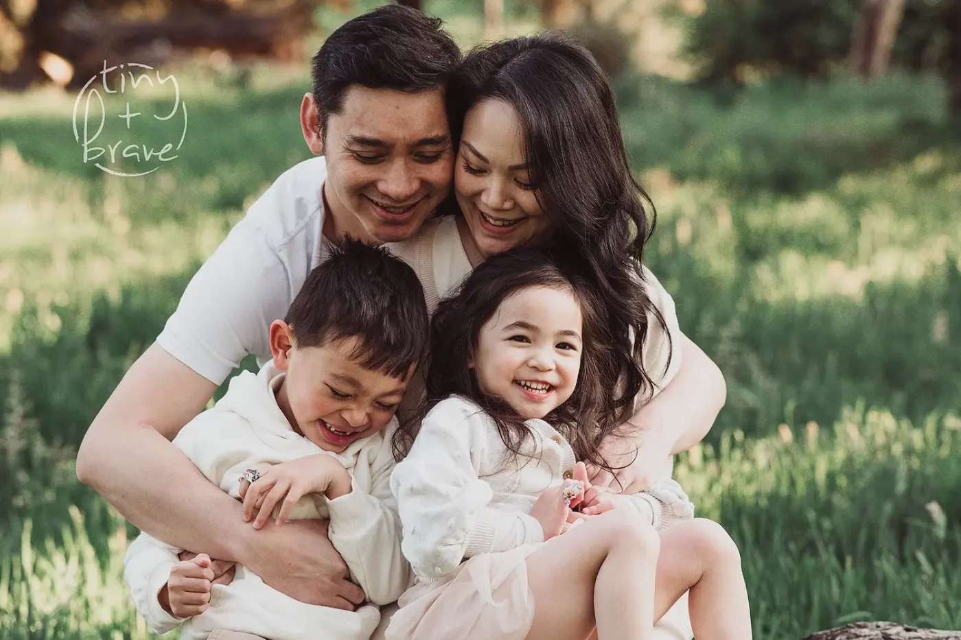 A family laughing together on the grass